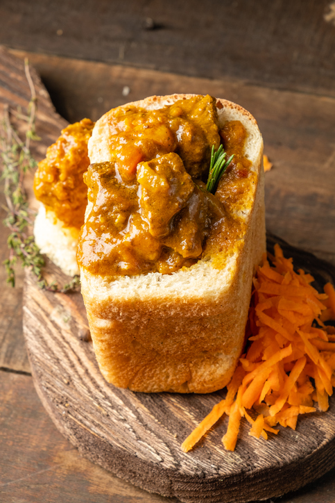 Ein fertiges Bunny Chow Curry in einem ausghölten Brotlaib.